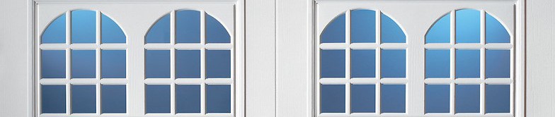White garage door windows with a double arched 9-pane grid design and blue-tinted glass.